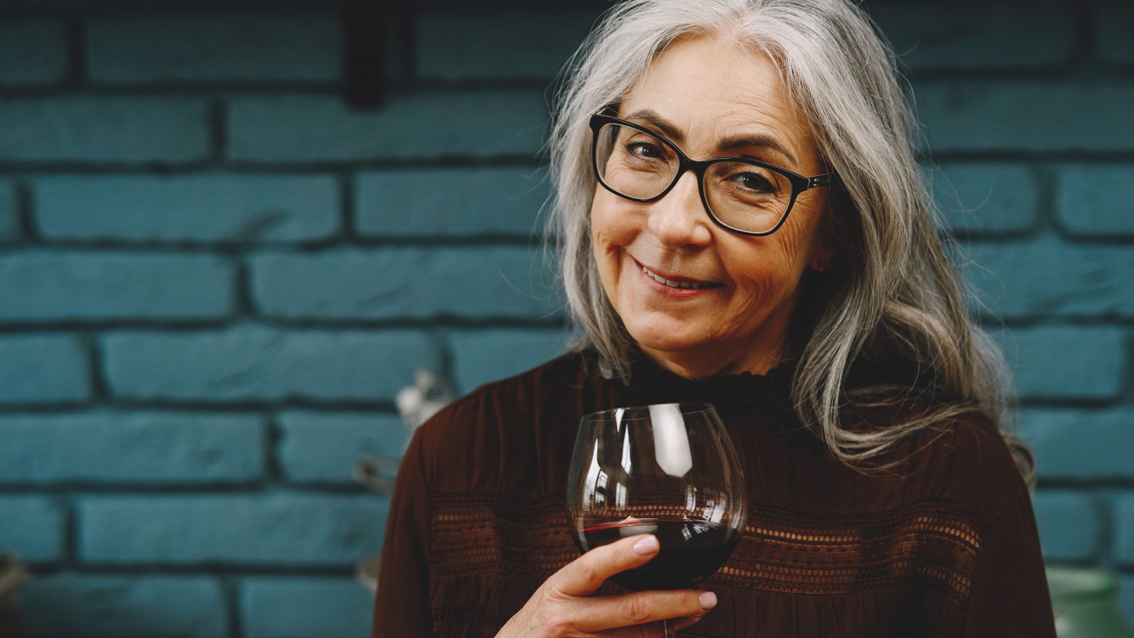 Portrait éditorial doux d'une femme en périménopause dans des tons chauds